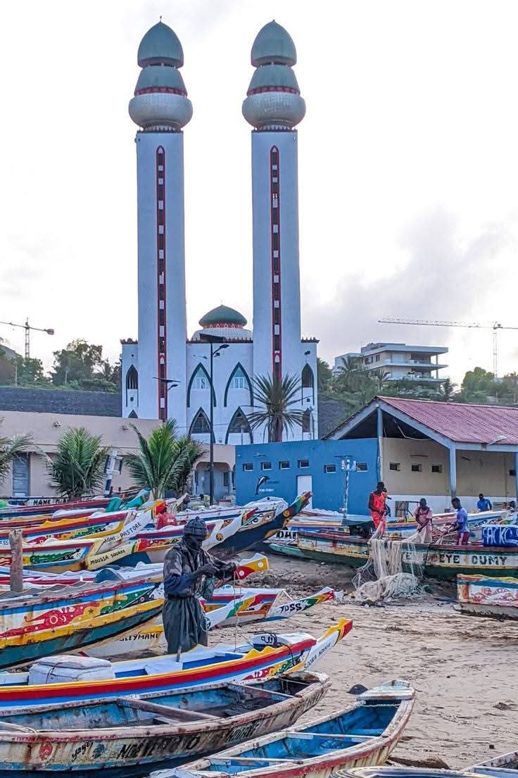 Fishing boats in front of a twin-minaret mosque