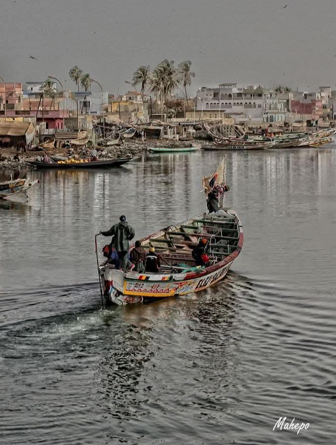 Fishing pirogue on the river with village houses